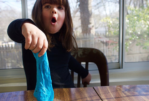 Easy slime recipe, girl playing with homemade blue slime.