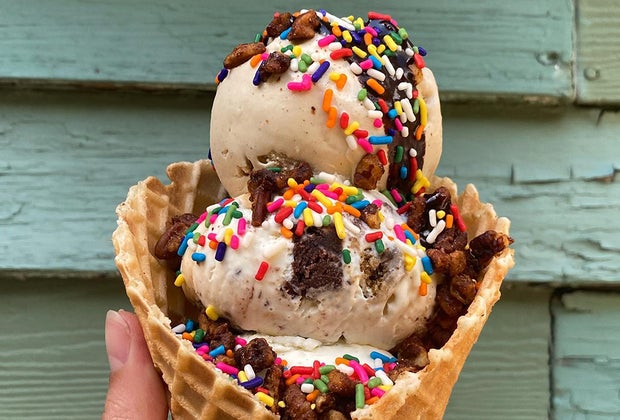 a triple scoop with rainbow sprinkles in a waffle cone