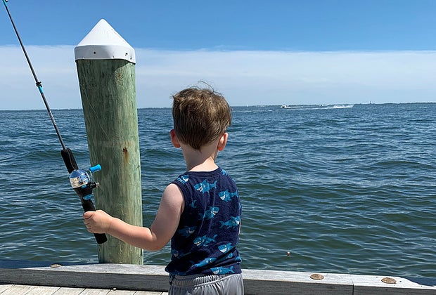boy fishing on a waterfront dock