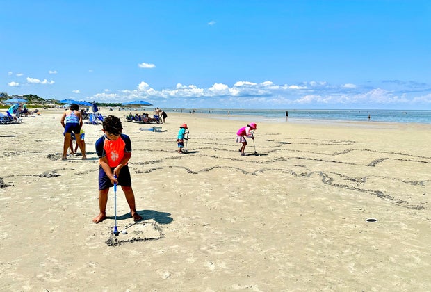 little boy playing mini golf on the beach at Ocean's Edge Resort