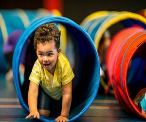 Baby crawling through tunnel. Photo courtesy of Canva