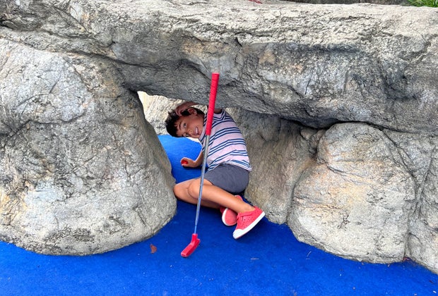 Image of child crawling under an obstacle at a mini golf course in CT