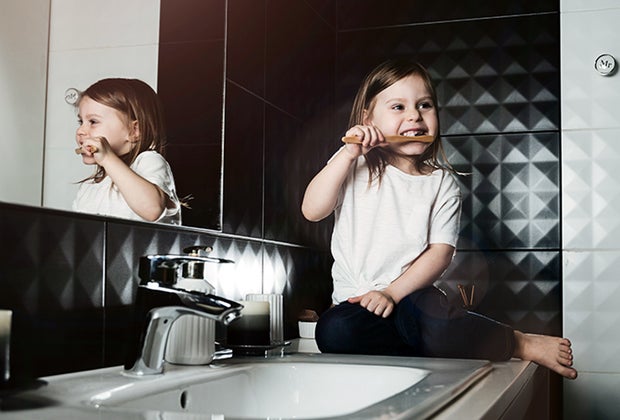 tricks for how kids can conserve water girl brushing her teeth at the sink