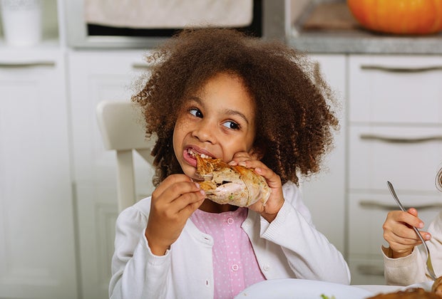 Girl devouring turkey, just like in this Thanksgiving Joke for kids!
