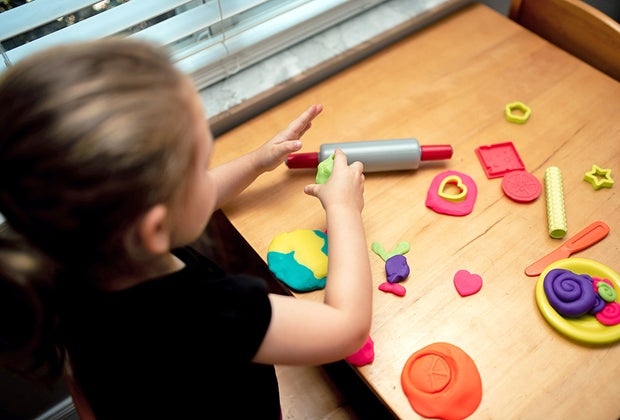 Girl playing with playdough to combat boredom.