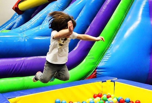 Kid jumping in a ball pit at Bounce N Play trampoline park in Queens