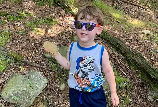 Boy hiking on trail in the woods