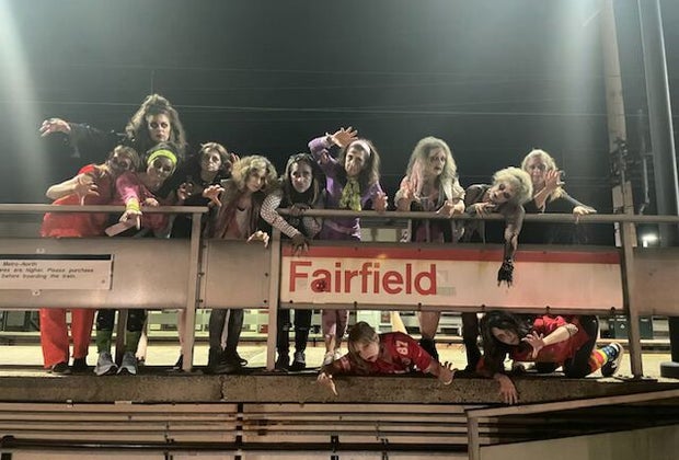 Image of MOMbies in zombie costume with Fairfield sign.