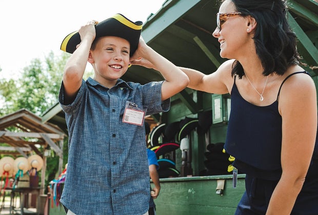 Things To Do in Williamsburg, VA with Kids: mom and boy trying on colonial style hat