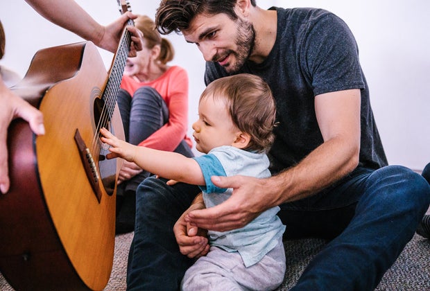 dad plays guitar with baby