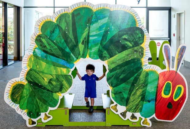Image of child with the Very Hunger Caterpillar artwork.