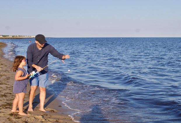 Photo of father and daughter fishing on a Cape Cod beach.