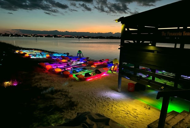 As the sun sets, the lights come on at Glow Paddle, illuminating the boats and the creatures under the sea.
