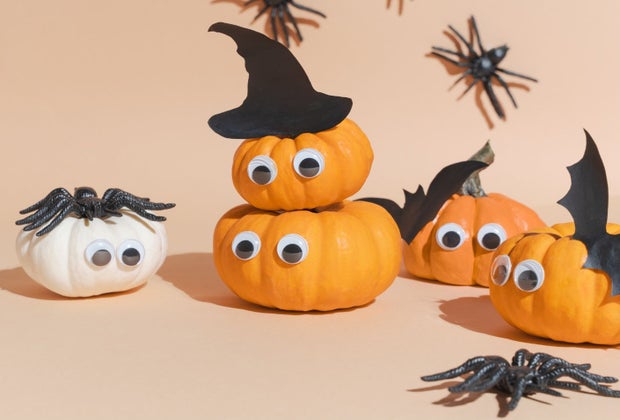 google eye pumpkins with cutouts of bats and witch hats