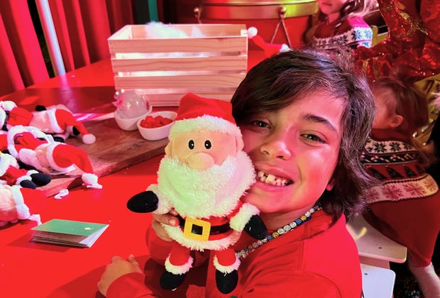 Passport to Santa: Boy poses with stuffed Santa character