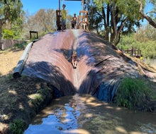 Slide into muddy fun at Adventure Playground! 