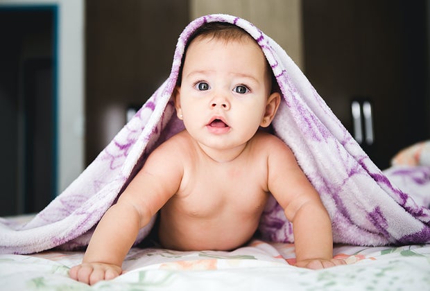 Cute baby with blanket on its head