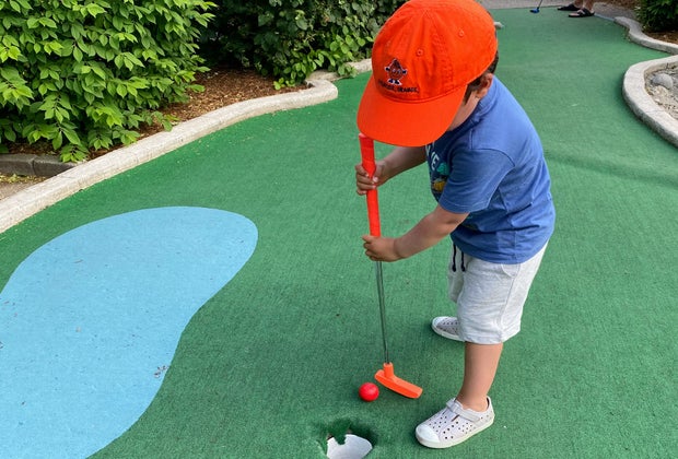 Photo of child putting - Best Mini Golf Courses for CT Kids
