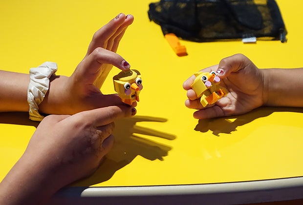Little hands hold Lego chick creations