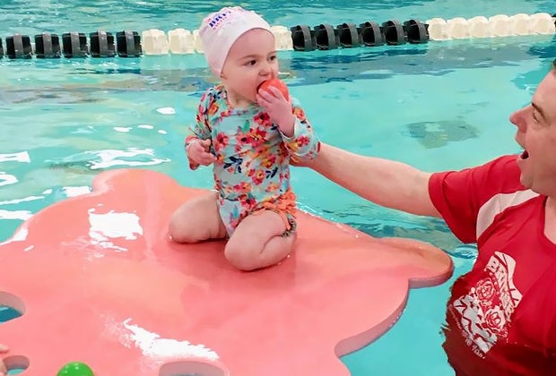 baby floating in pool on lily pad