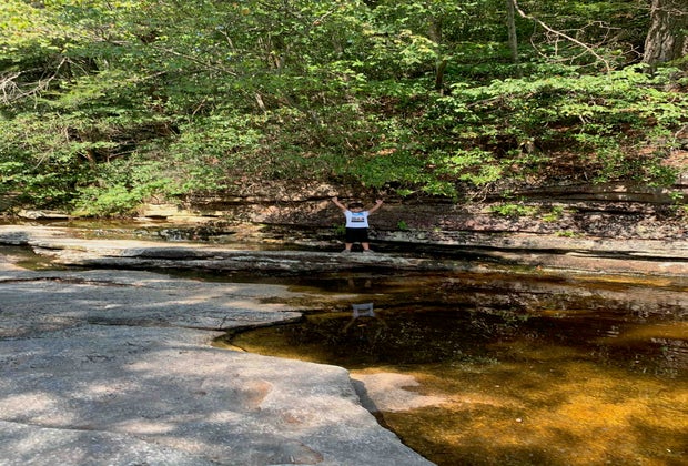 A boy poses on a rock outcropping near Awosting Falls in Lake Minnewaska State Park and Preserve