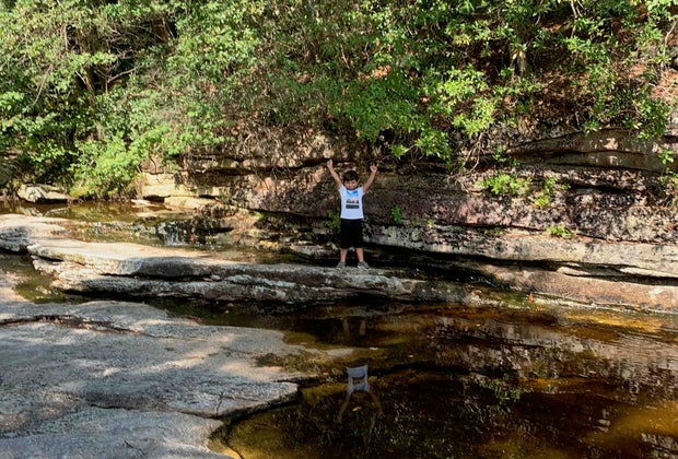 A boy poses on a rock outcropping near Awosting Falls in Lake Minnewaska State Park and Preserve