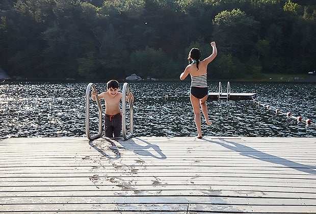 Family-friendly hotels in the Hudson Valley: Kids jumping off a dock into a lake at Mohonk Mountain House