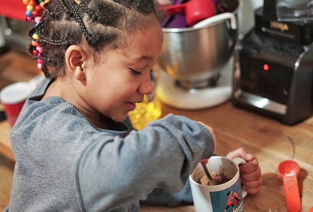 Little girl mixes mug cake