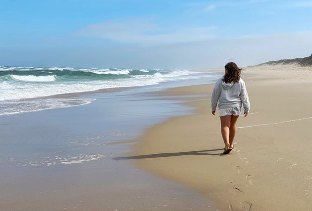 Picture of a person walking along the shore of a Cape Cod beach.