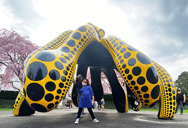 girl standing at Dancing Pumpkin kusama exhibit at NYBG