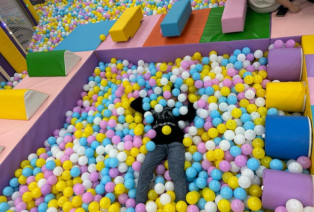 Indoor playground Rainbow Playpace: Kid hiding in the ballpit