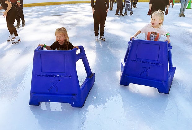 Ice skating at Wollman Rink in Central Park with kids: Close up of two girls with skate aids