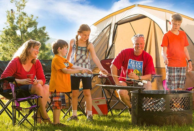 Photo of a family roasting marshmallows at a campsite