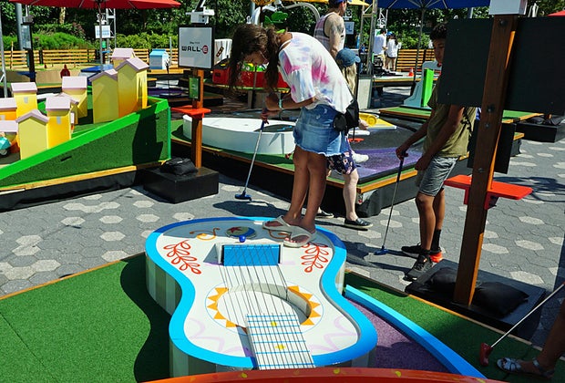 Girl plays Pixar Putt Coco hole