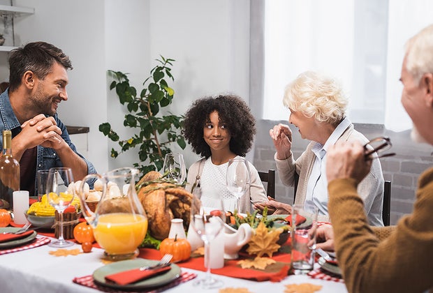family around a dinner table 101 Questions To Ask Grandparents About Their Lives