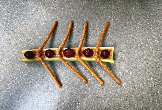 Olympic rowers snack with celery boat, grape people, and pretzel oars held together with peanut butter.