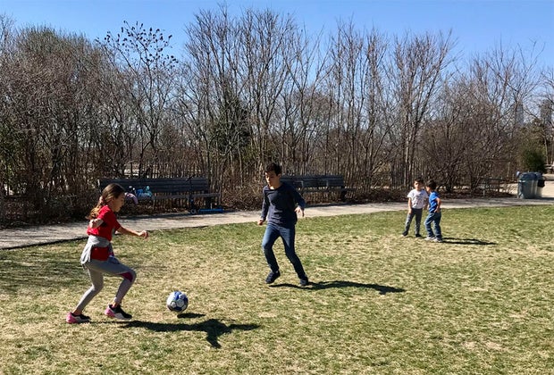 kids playing soccer in the grass