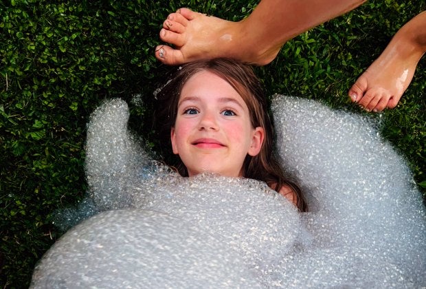 Getting buried in bubbles is much less messy than getting buried in sand! Photo by Ally Noel for Mommy Poppins