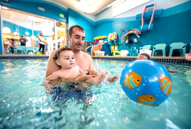 Small-group baby swimming lessons are a trademark of Goldfish Swim School.