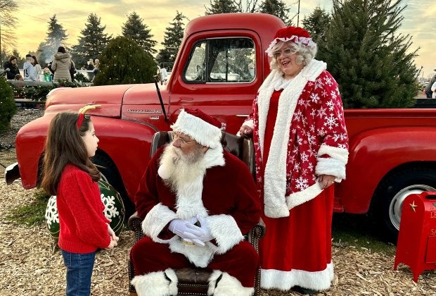 Mr. and Mrs. Claus have a great photo-op with a little red truck at Santa's Christmas Tree Farm in Cutchogue. Photo by Jennifer Voit