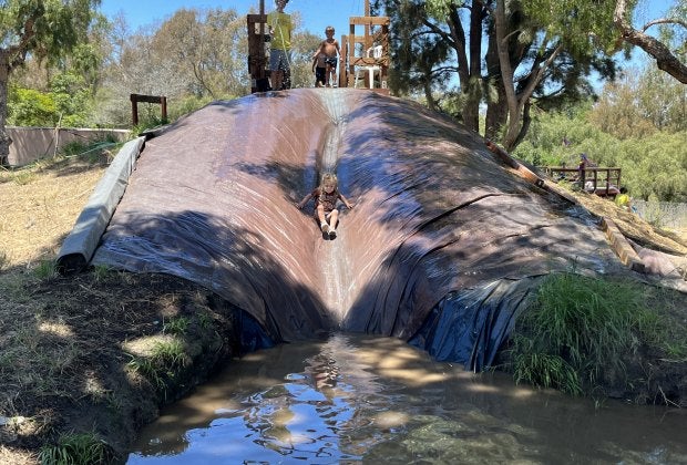 Slide into muddy fun at Adventure Playground!