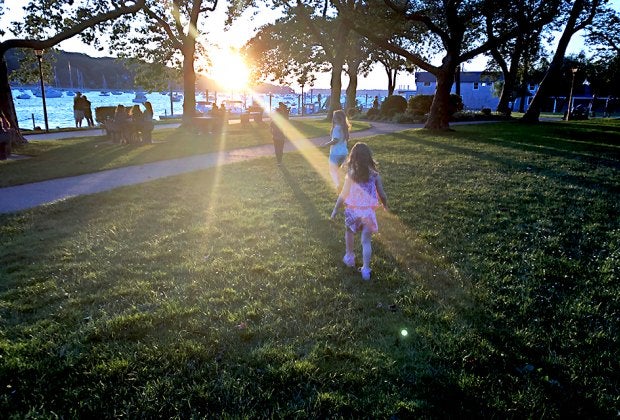 Families gather at Northport Park as the sun sets on the scenic Northport Harbor. Photo by the author