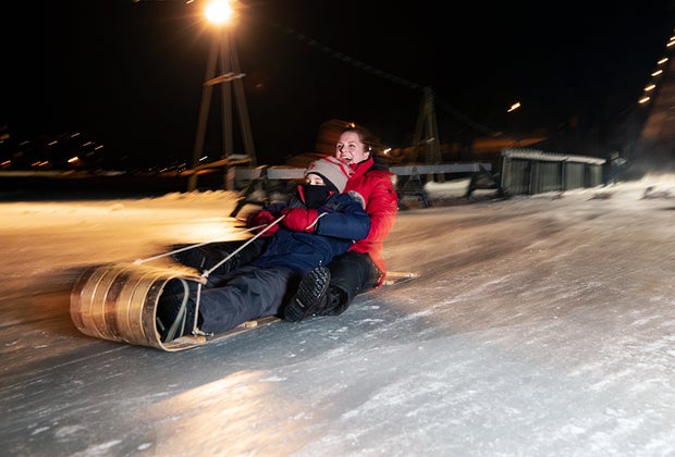 Things to do in Lake Placid with Kids: Toboggan Riding on Mirror Lake mother and son riding toboggan Things to Do in Lake Placid on a Winter Vacation Status message