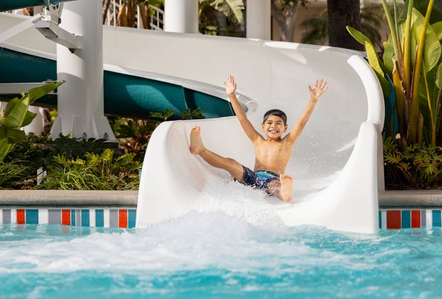 boy slides down The Twister into the pool with a huge smile