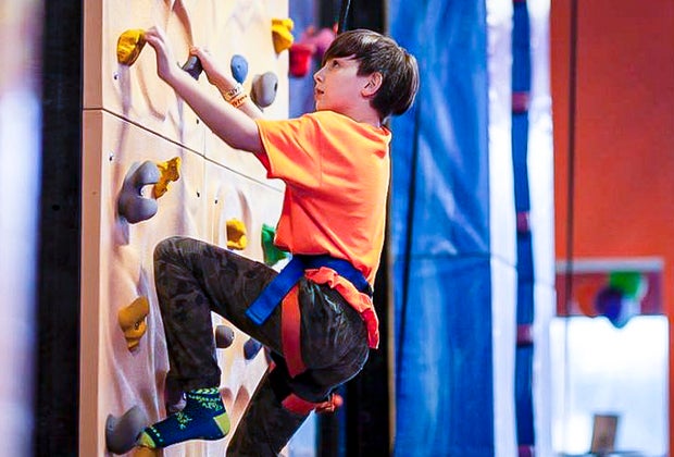 Image of child climbing rock wall at Urban Air Adventure Park in Connecticut.