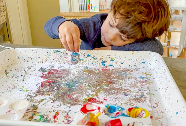 Dip a dreidel in some paint and spin it to create a beautiful piece of art.
