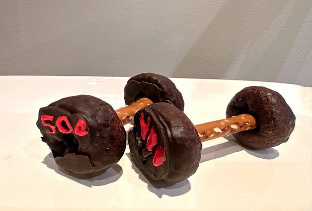 Dumbells made with chocolate covered mini donuts and pretzel sticks.