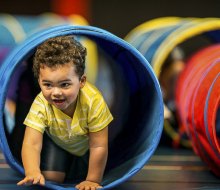 Baby crawling through tunnel. Photo courtesy of Canva