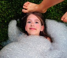 Getting buried in bubbles is much less messy than getting buried in sand! Photo by Ally Noel for Mommy Poppins