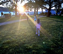 Families gather at Northport Park as the sun sets on the scenic Northport Harbor. Photo by the author